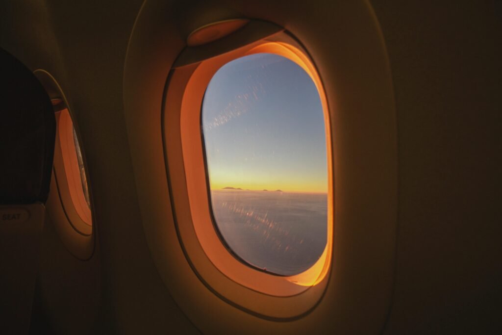 View of the sunrise from an airplane window over Bali, Indonesia. Stunning sky colors and clouds.